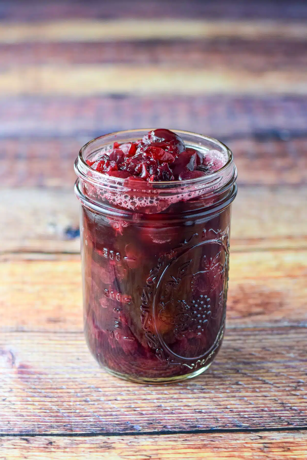 Jar of cherry sauce on a wooden table