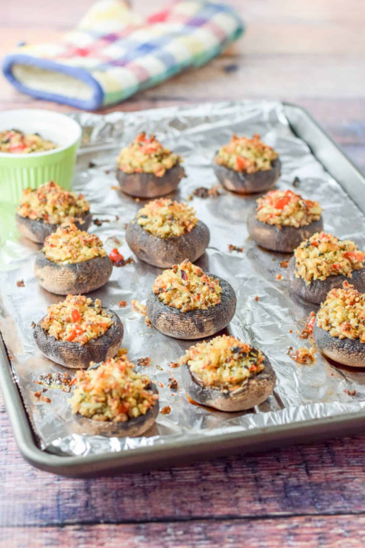 A foil lined pan with the crab mushrooms fresh out of the oven