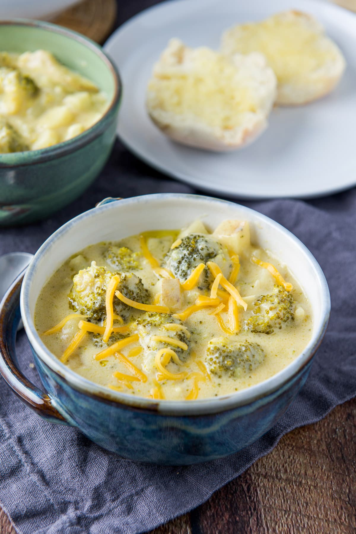 close up view of the soup in two bowls with a roll in the back