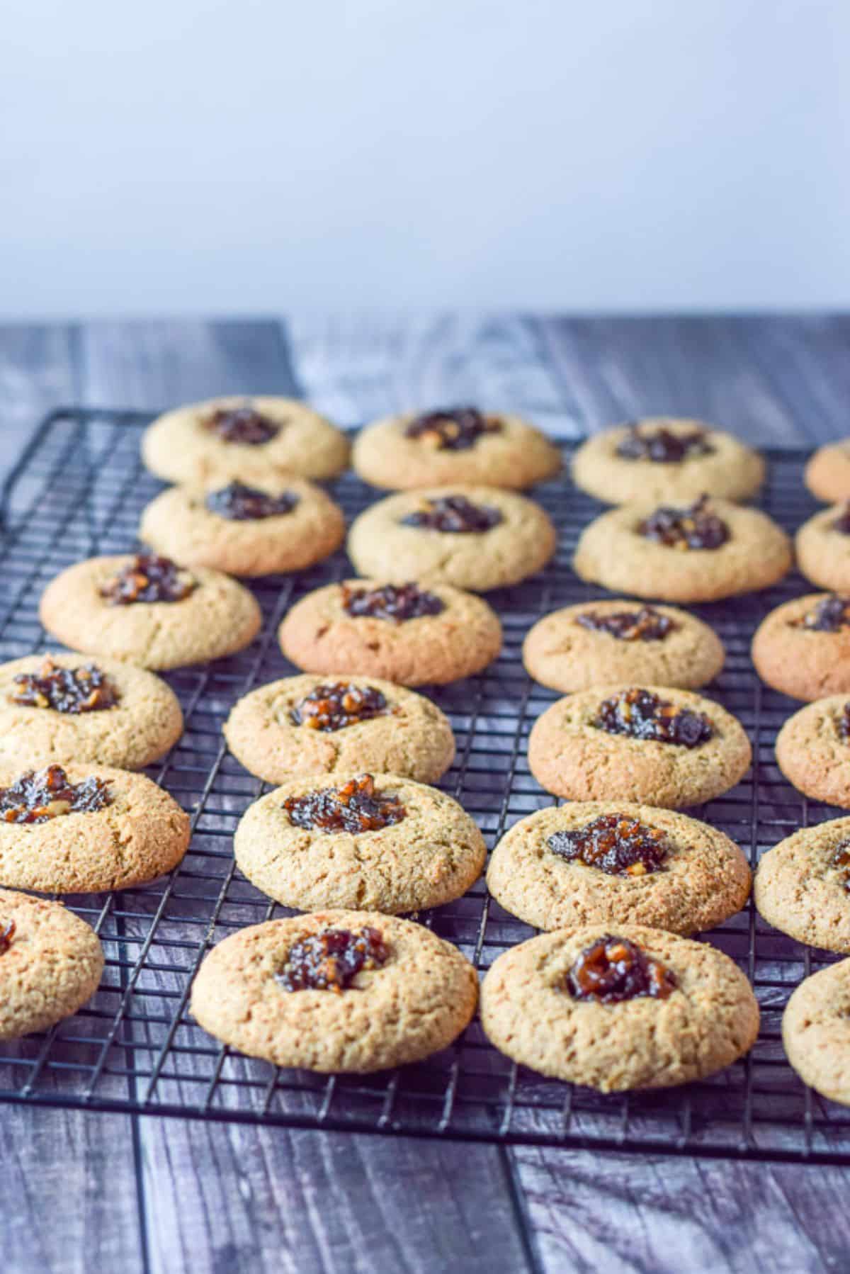 Date cookies cooking on a black wire rack