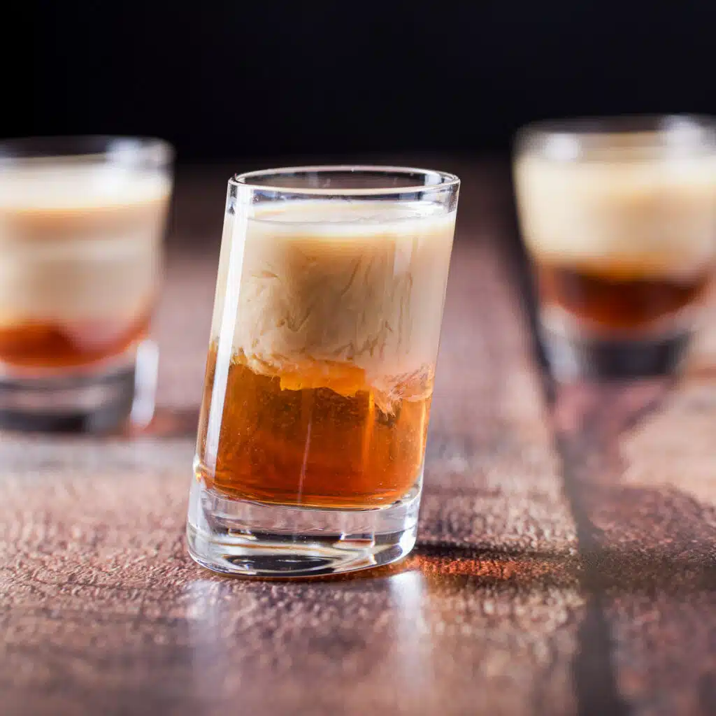 square photo of the three shot glasses with the layered drink in it