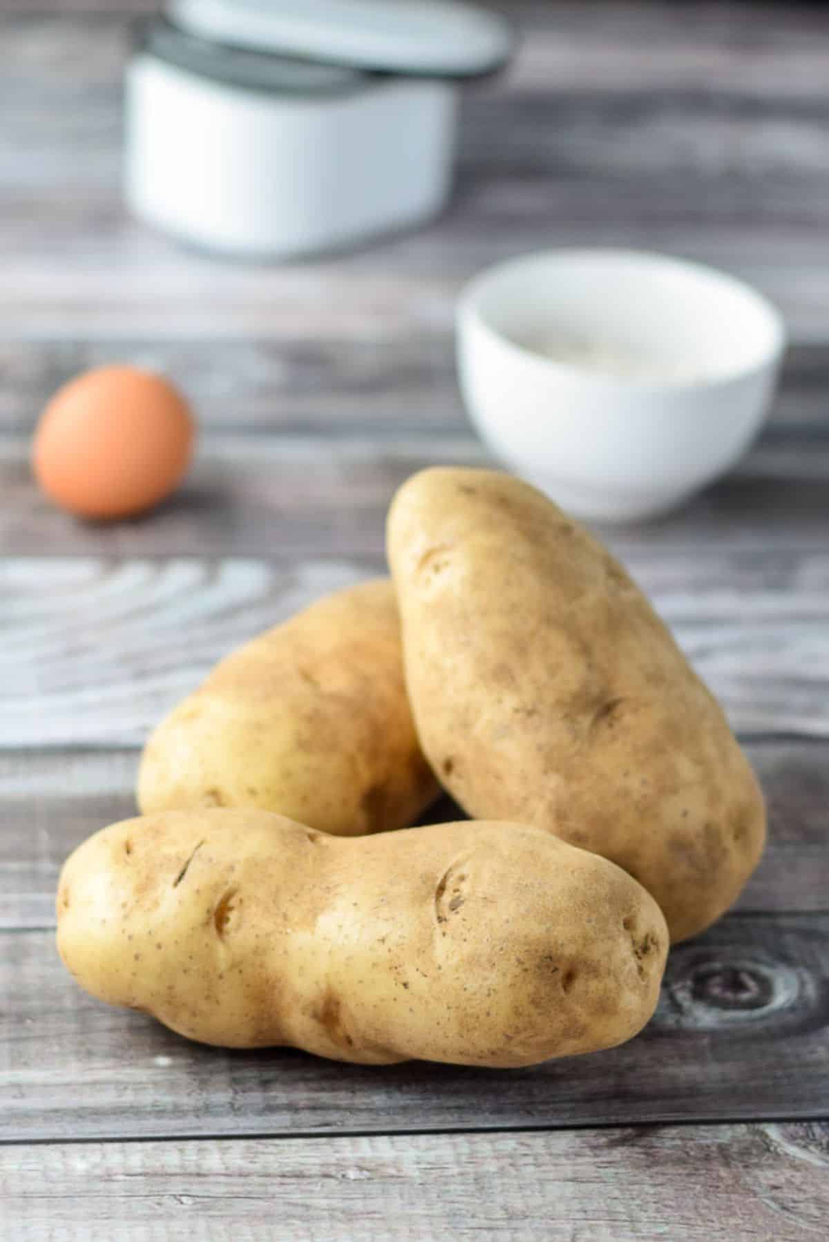 Potatoes, egg, flour, and salt on a table