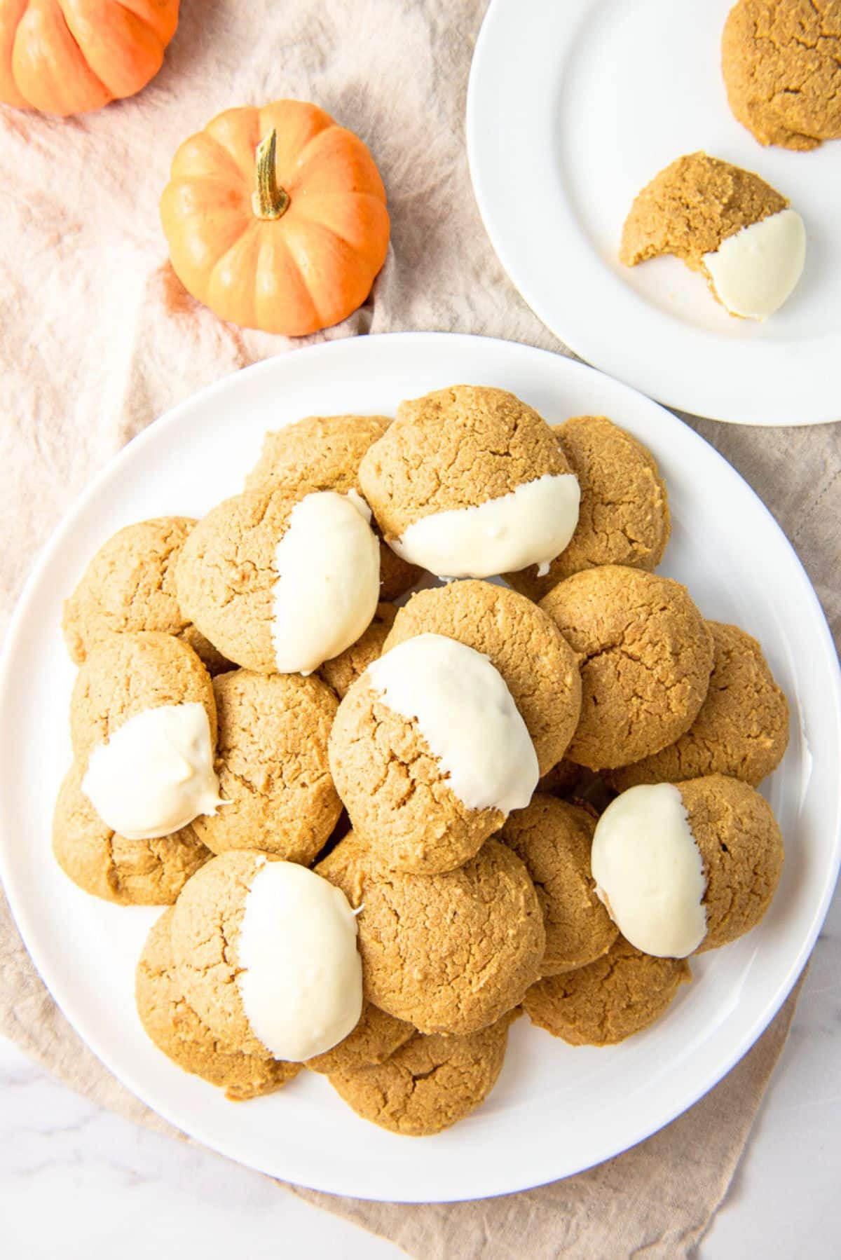 Overhead view of the big plate of cookies with small pumpkins and a small plate with cookies