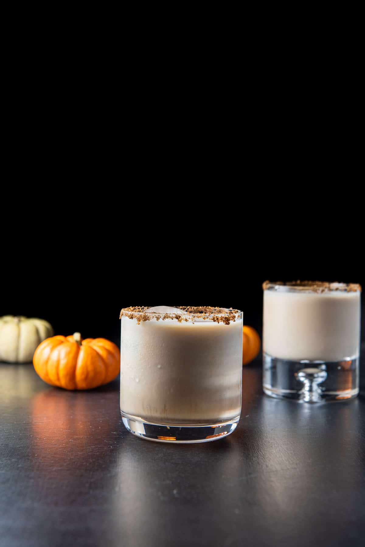 Vertical view of the white Russian in the shorter glass in front of the bubble glass