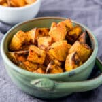 square photo of a green bowl filled with the potatoes