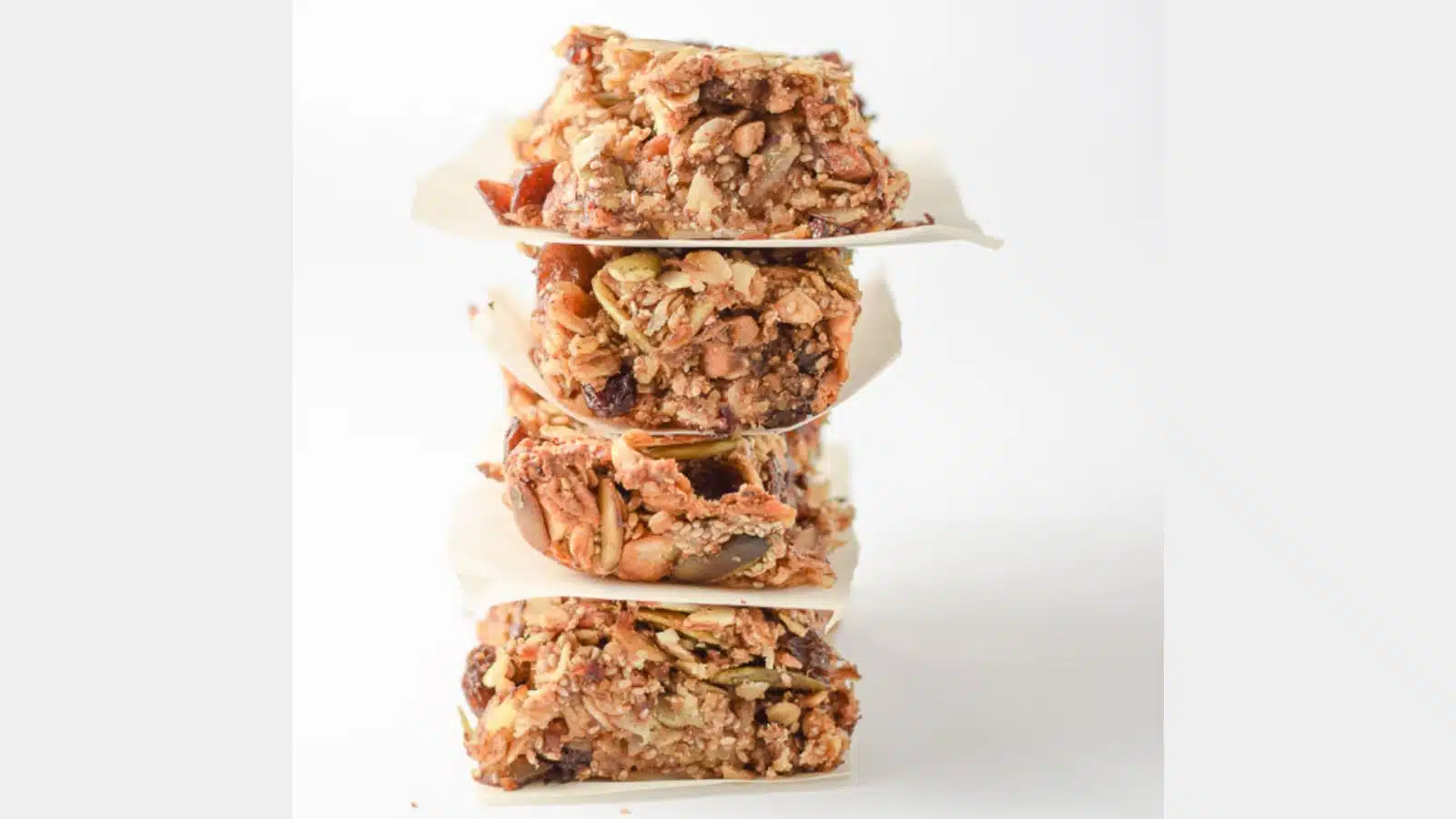 A stack of four granola bars tilting to the right with a white background