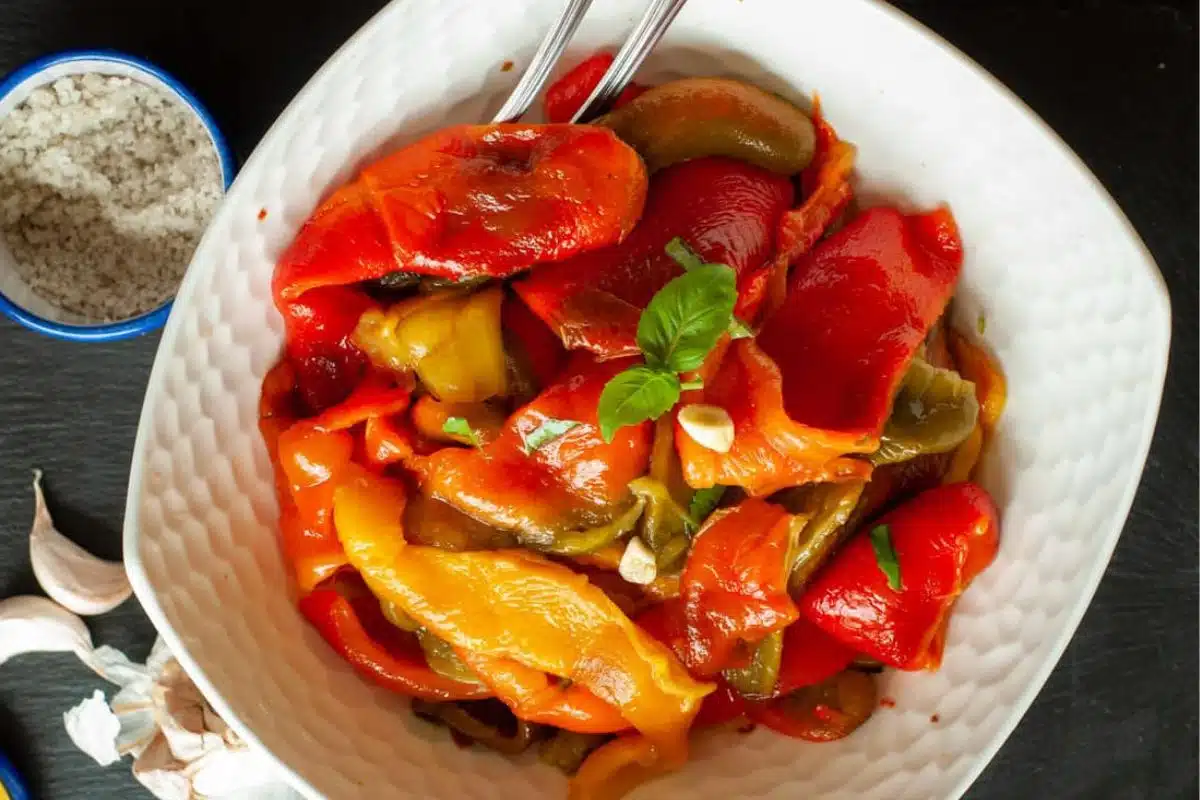 A white bowl with roasted peppers in it