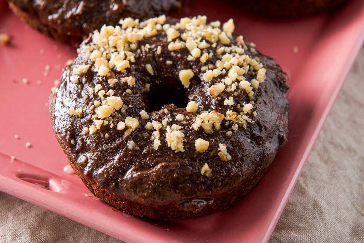 horizontal photo of a chocolate donut on a red plate