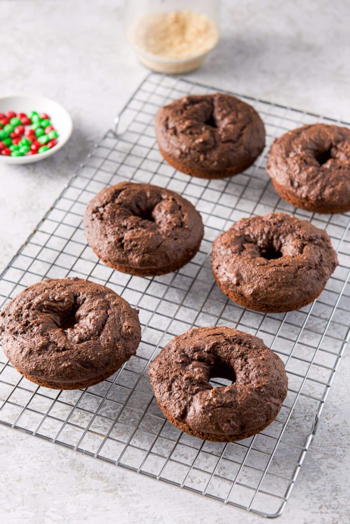 Freshly baked chocolate donuts on a wire rack