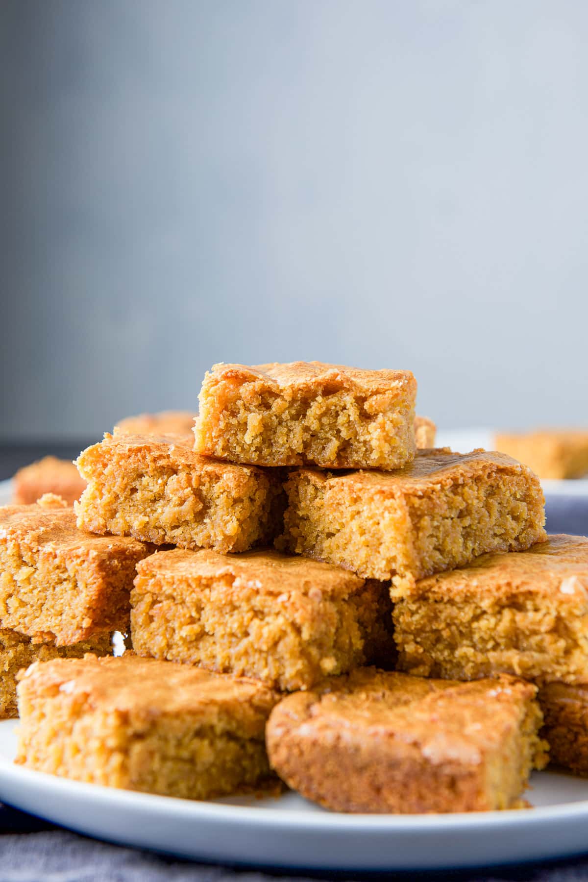 A vertical view of the pile of butterscotch squares on a white plate