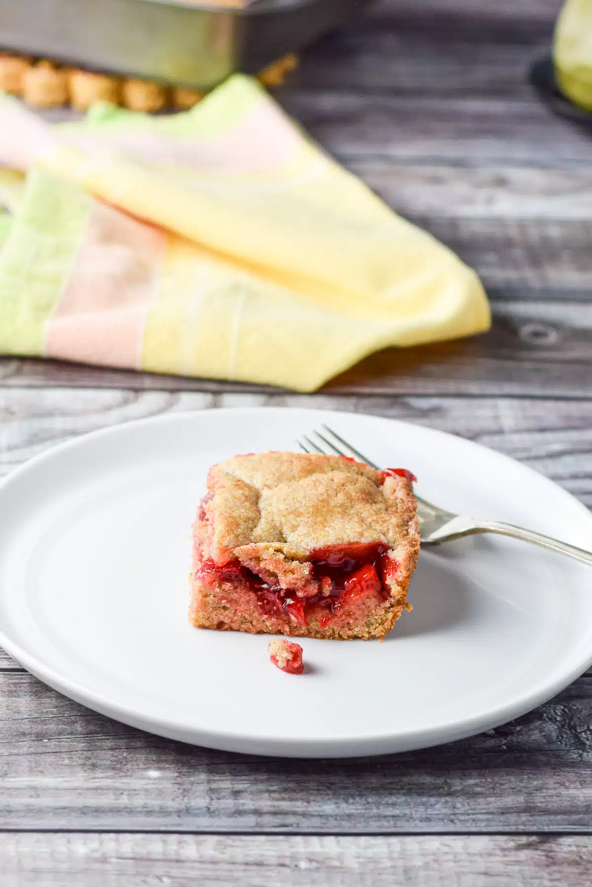 A with plate with the cherry dessert on it and the pan in the background