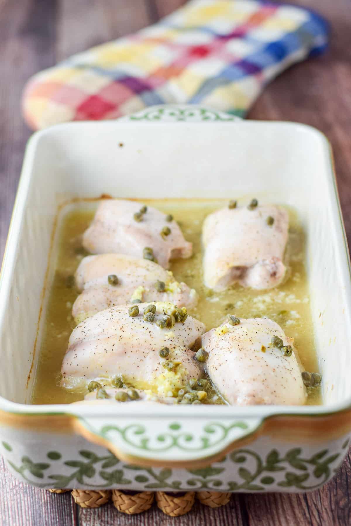 A baking dish with the chicken piccata fresh out of the oven