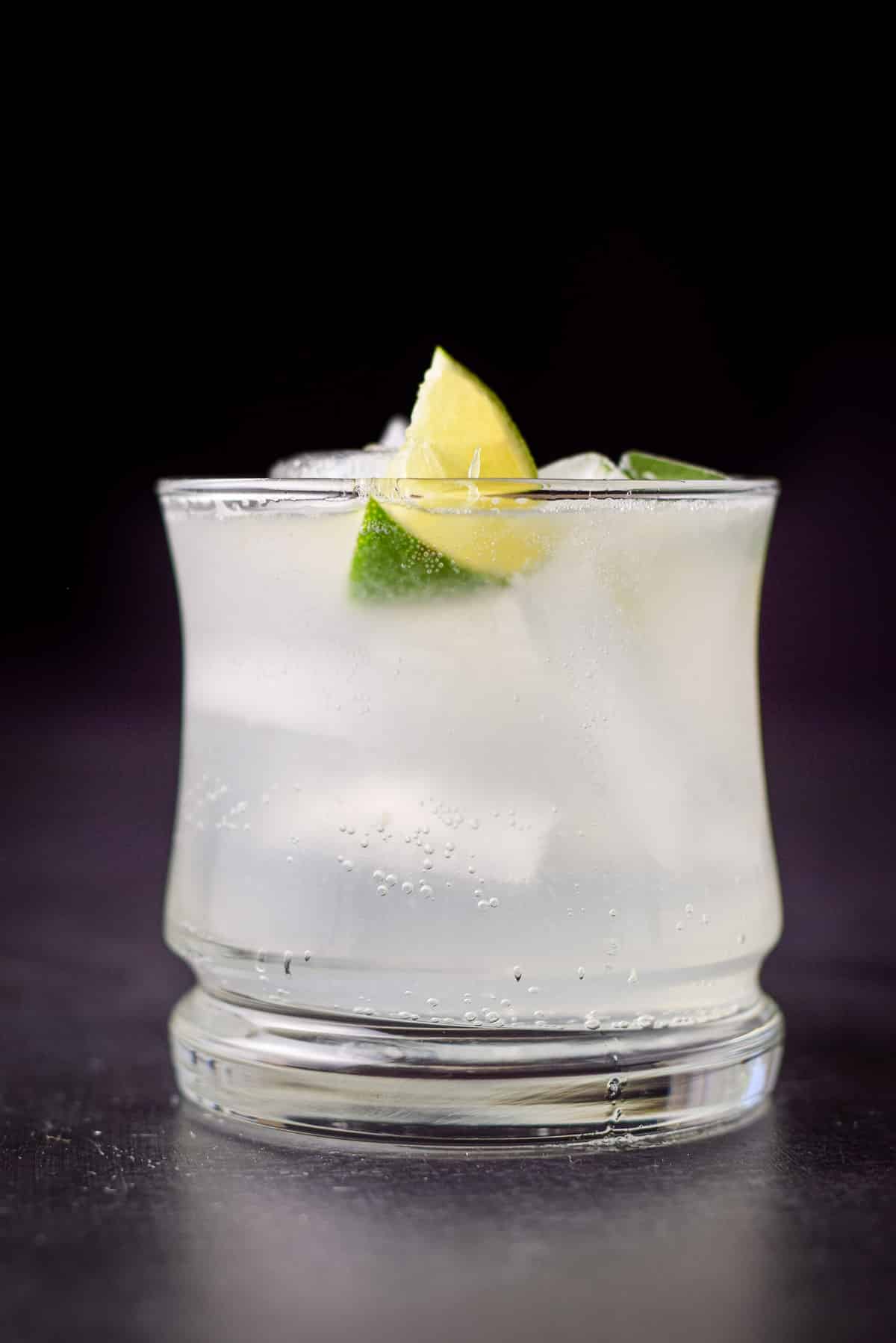 Vertical view of the gin drink with two lime wedges