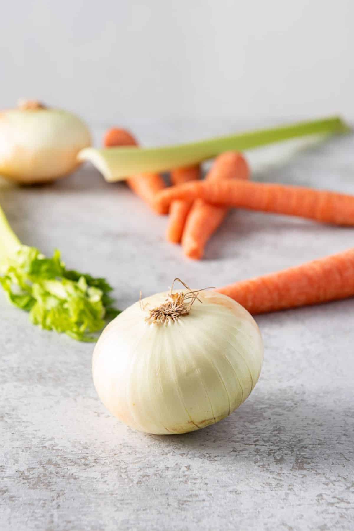 Onions, carrots, and celery on a table for the soup