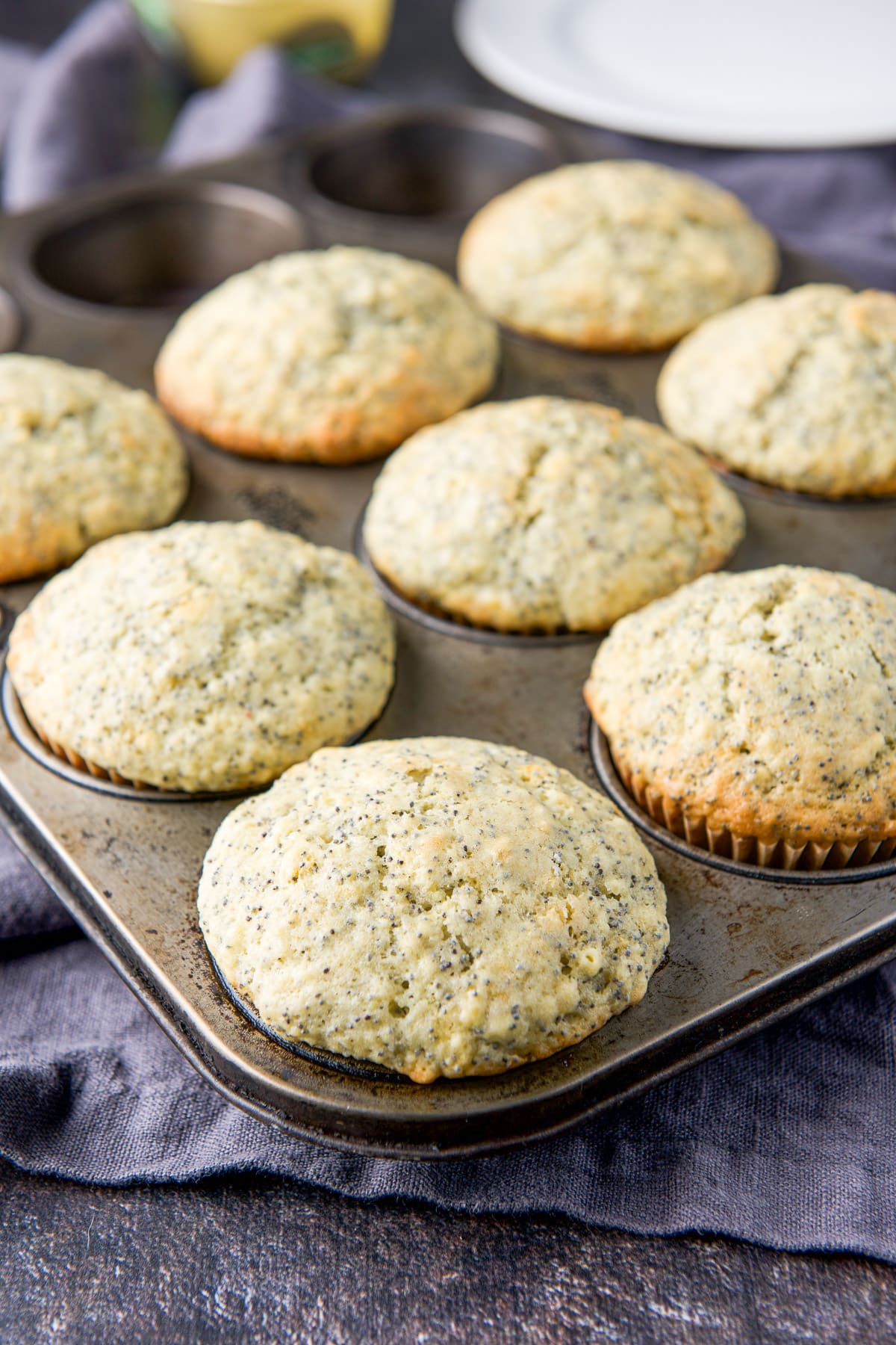 A muffin tin with the lemon muffins fresh out of the oven