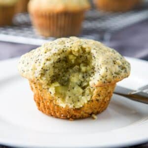 Square photo of A bite taking out of a muffin that was slathered with butter