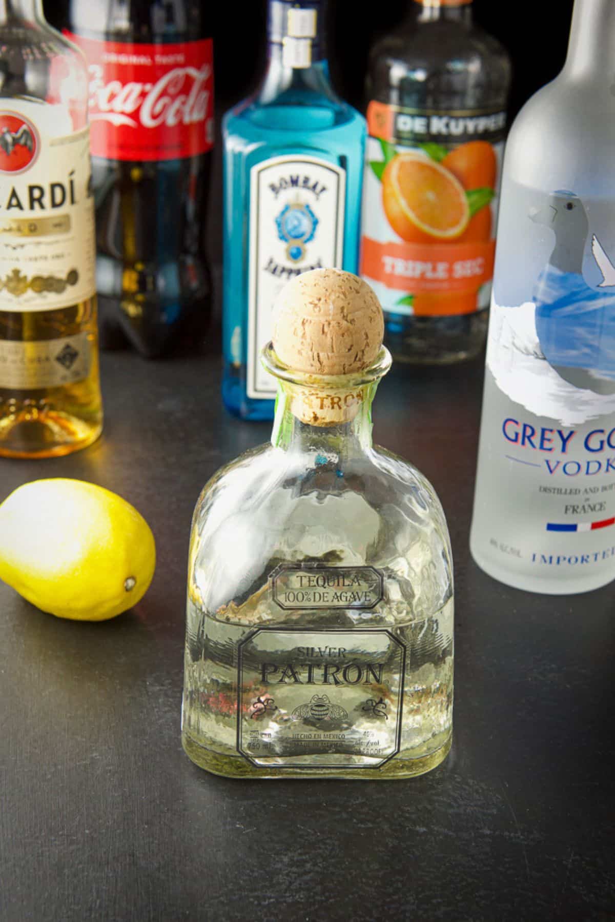 Tequila, vodka, gin, rum, triple sec, lemon and soda on a table