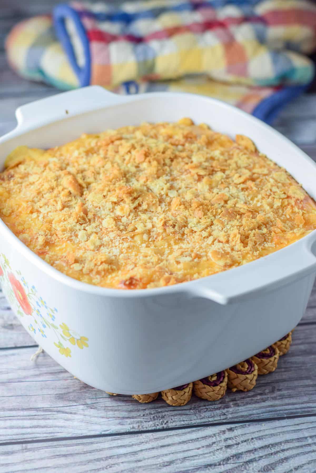 A casserole dish with ritz crackers sprinkled on mac and cheese and straight out of the oven