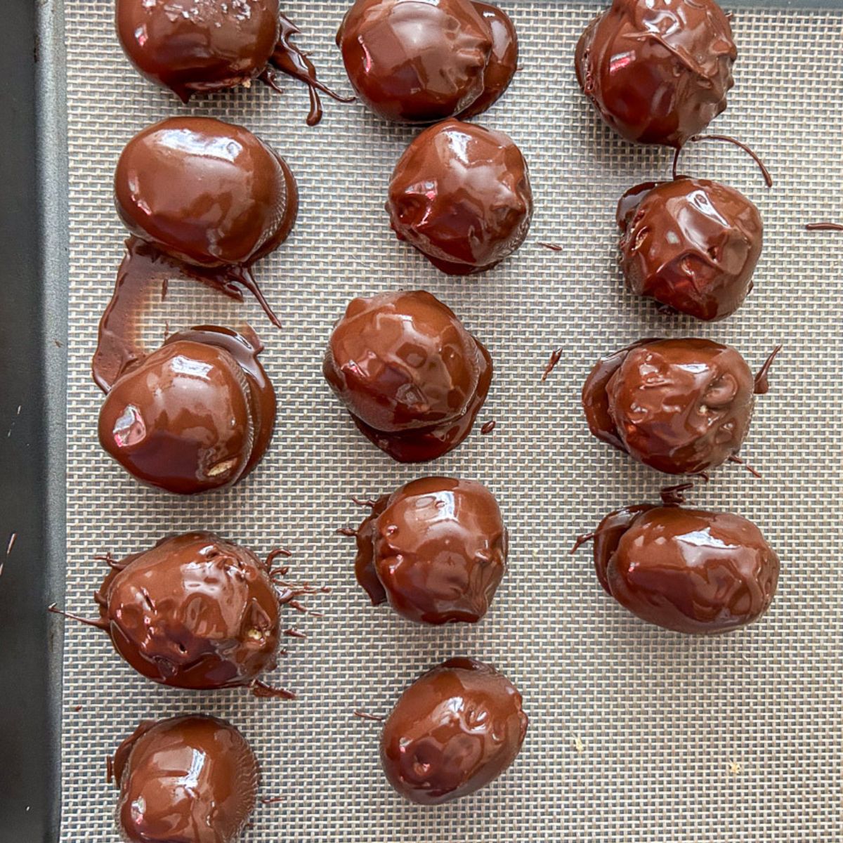 Freshly dipped chocolate peanut butter balls on a tray