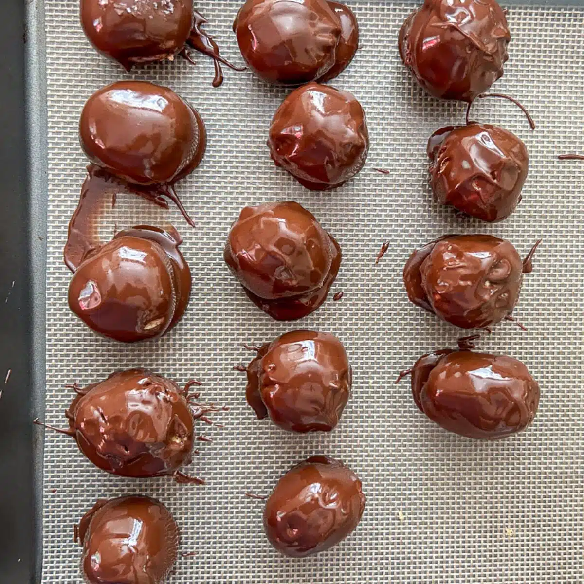 Freshly dipped chocolate peanut butter balls on a tray