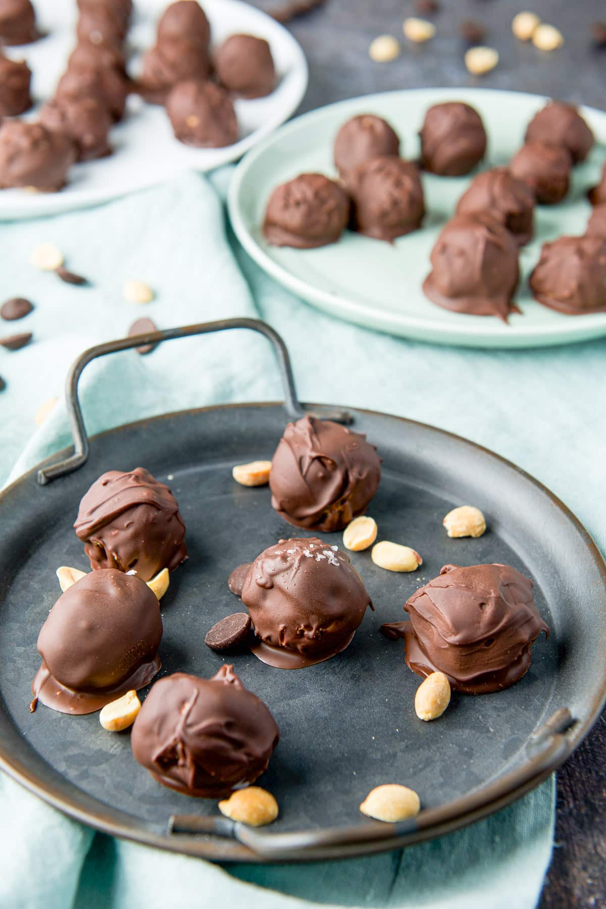 Close view of a round tray with the peanut butter balls on it along with more round dishes in the back
