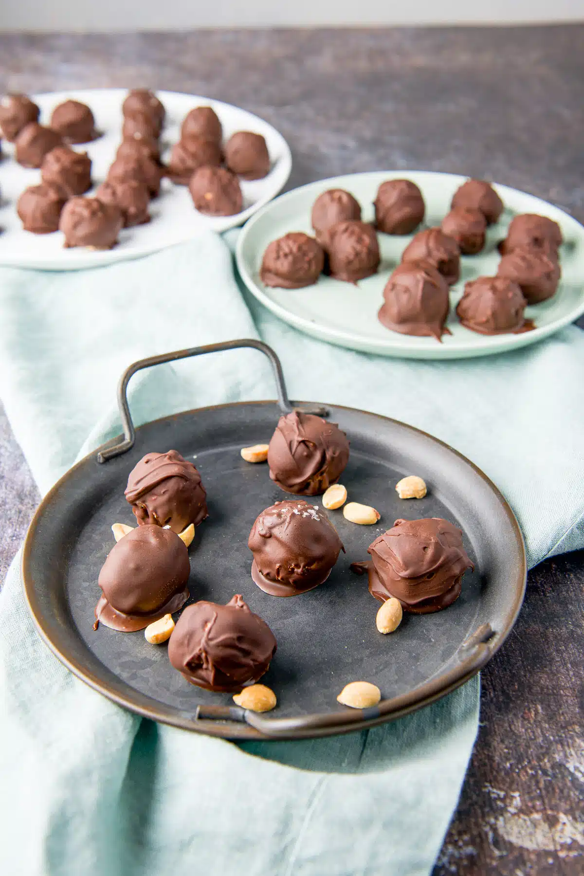 Three round dishes with the peanut butter balls on them