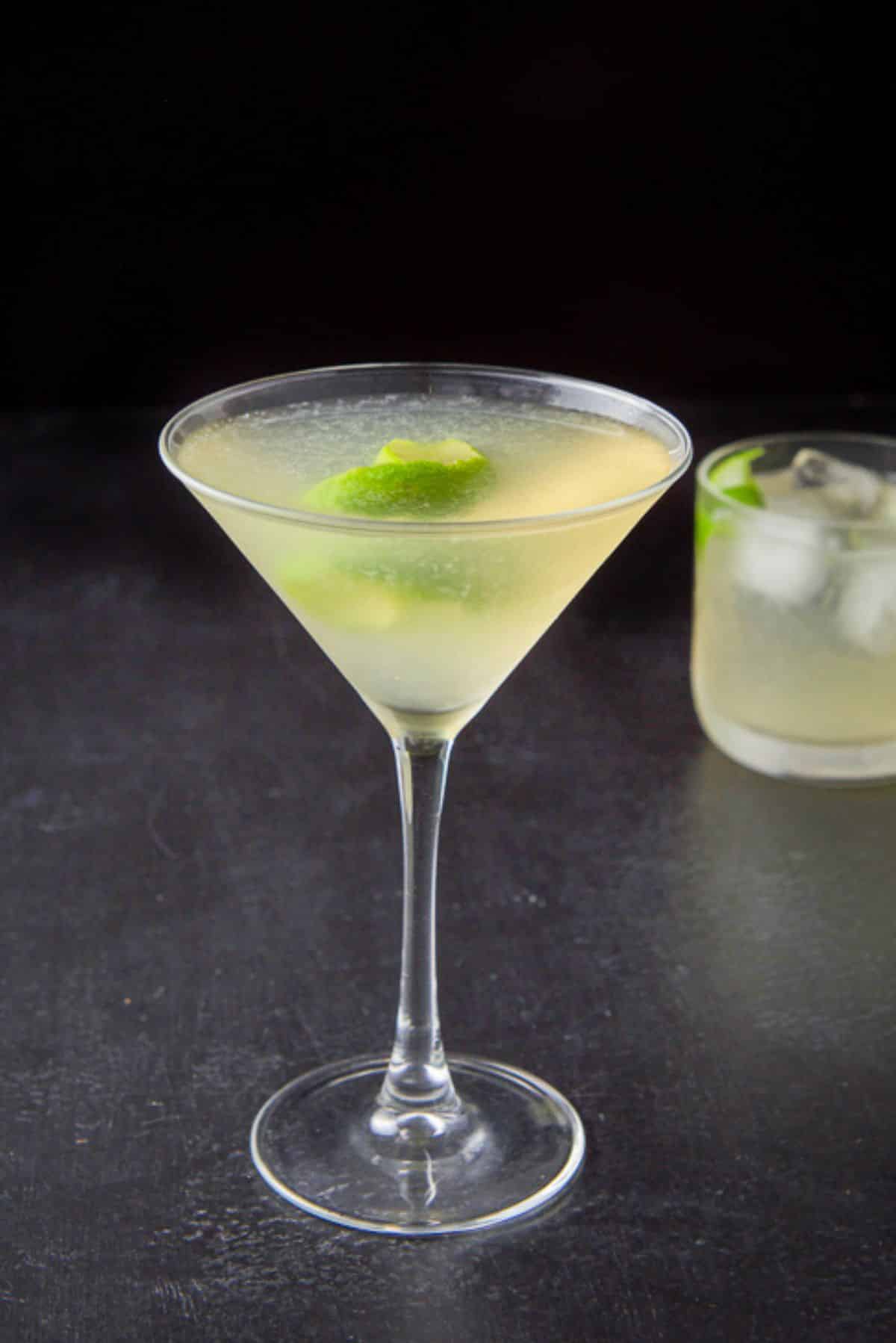The gimlet poured into the glasses with lime twists as garnish