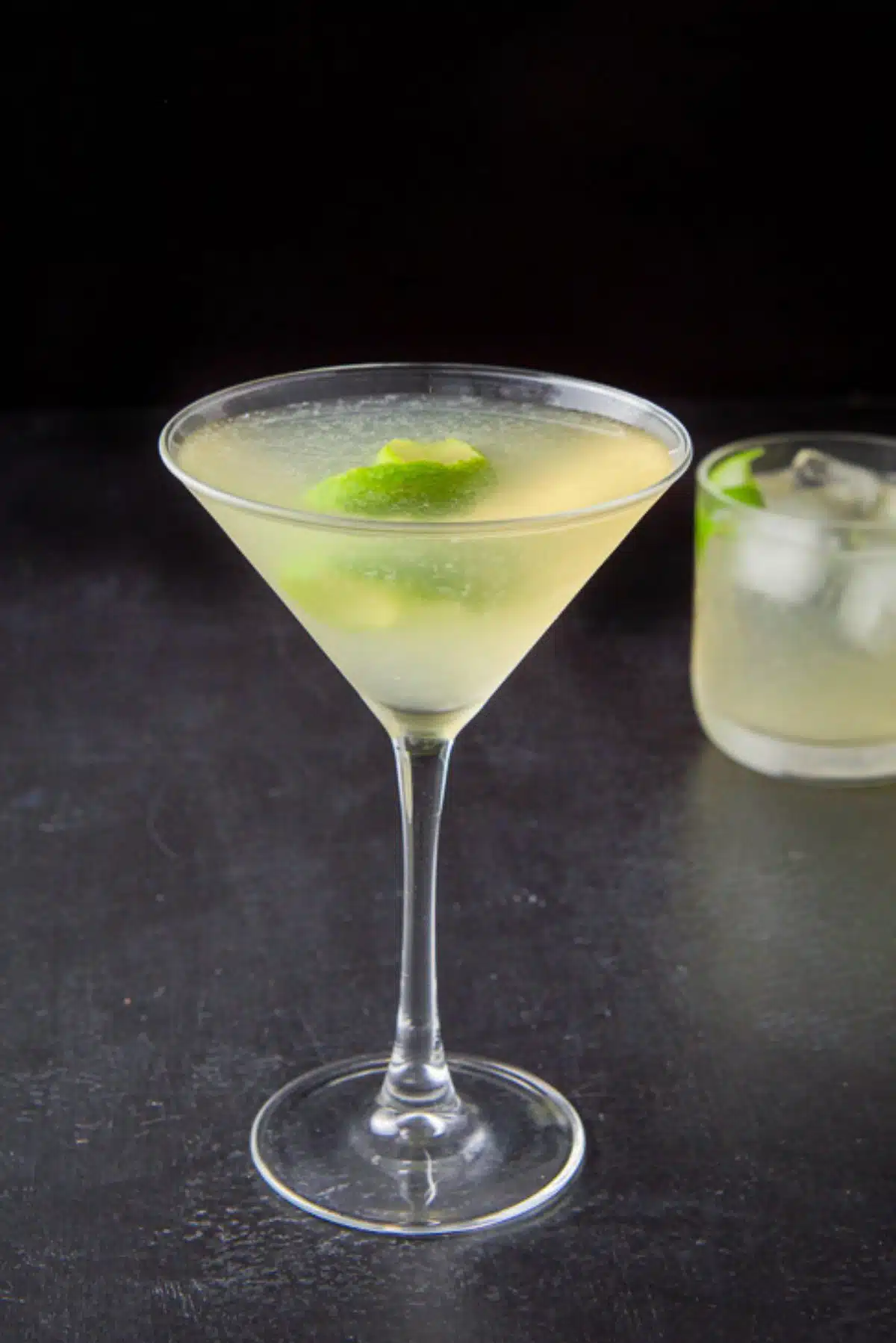 The gimlet poured into the glasses with lime twists as garnish