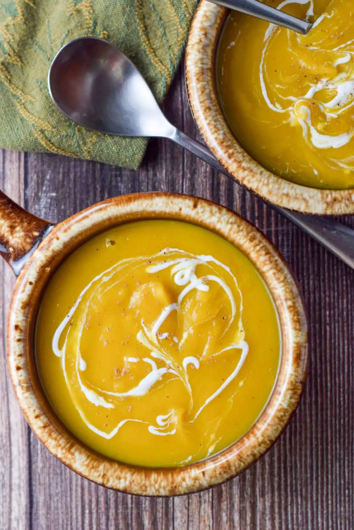 Overhead view of the two brown crocks with the soup and sour cream garnish