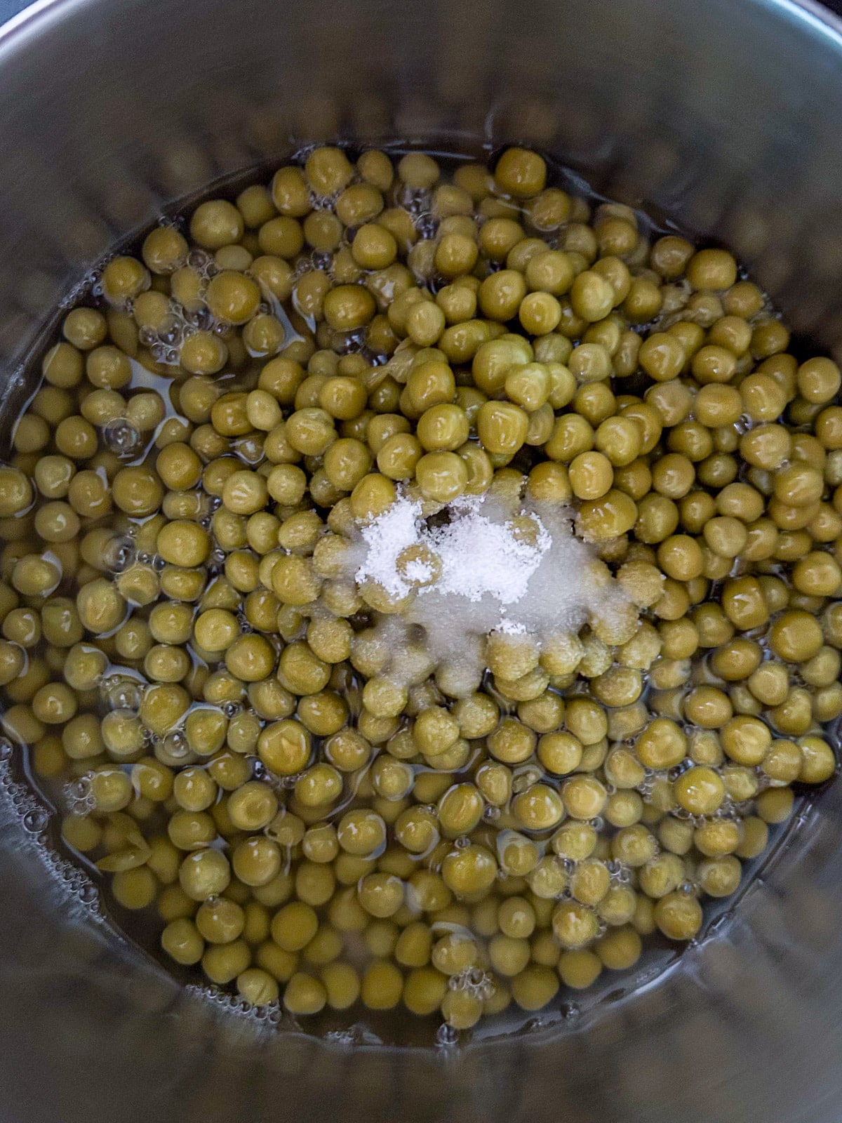 A pan with the canned peas and sugar
