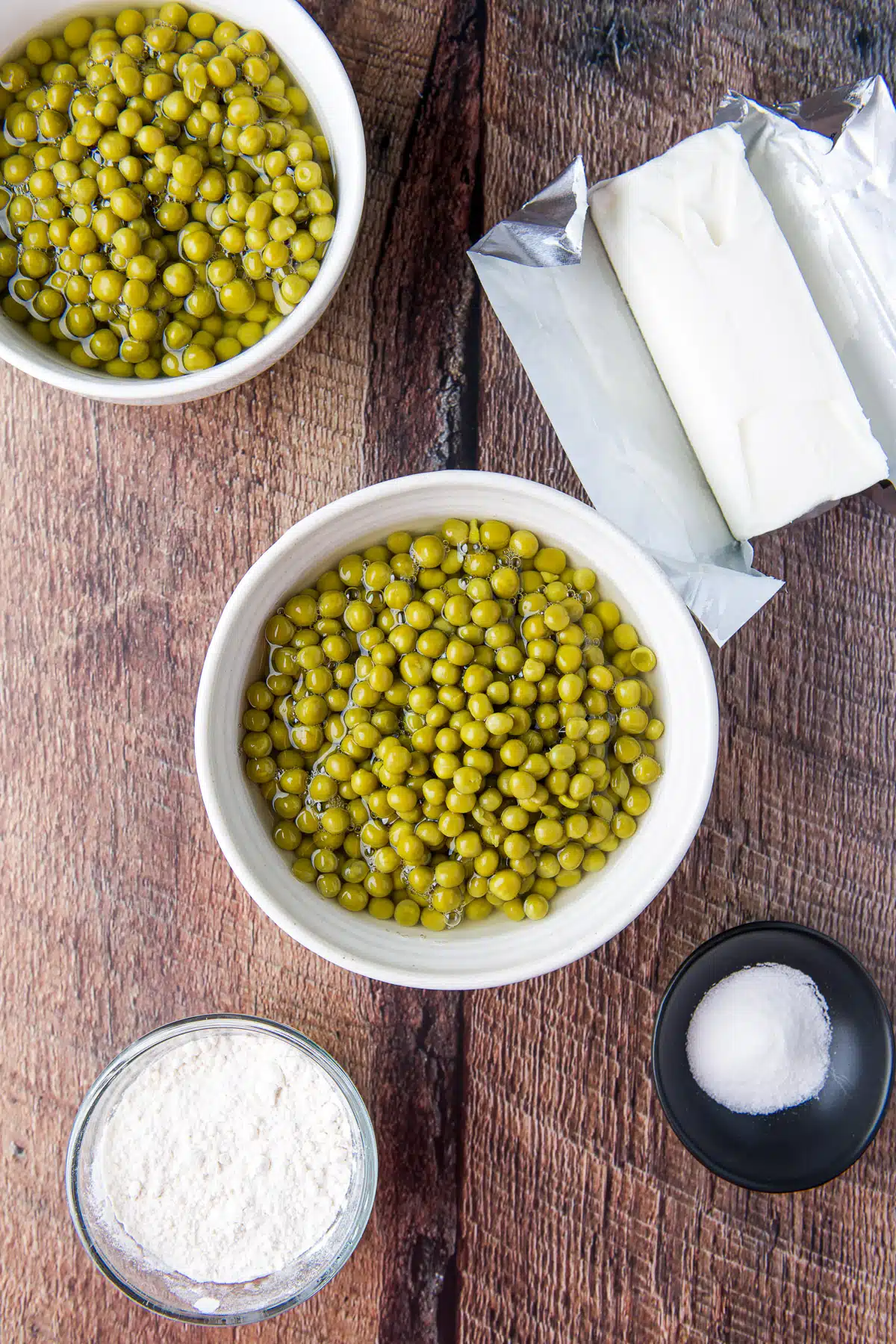 Overhead view of peas in two bowls, crisco, sugar, and flour