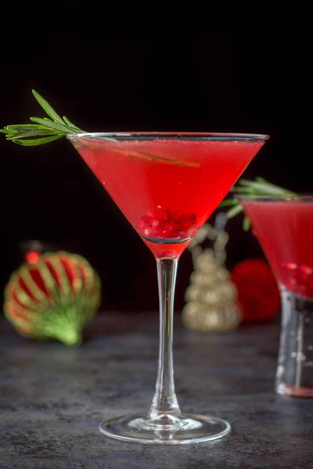 Vertical view of the pomegranate cocktail with rosemary and pomegranate seeds in the glasses