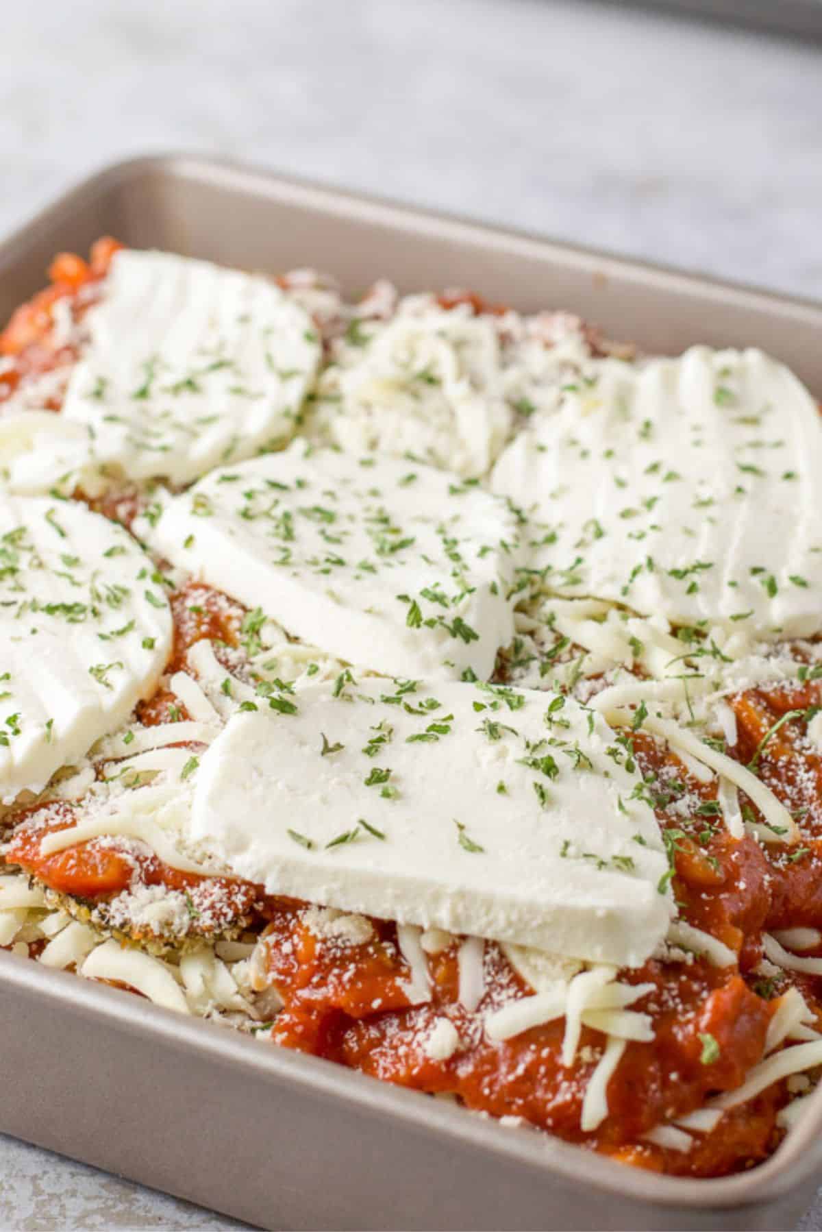 Thick slices of mozzarella on the unbaked parmesan