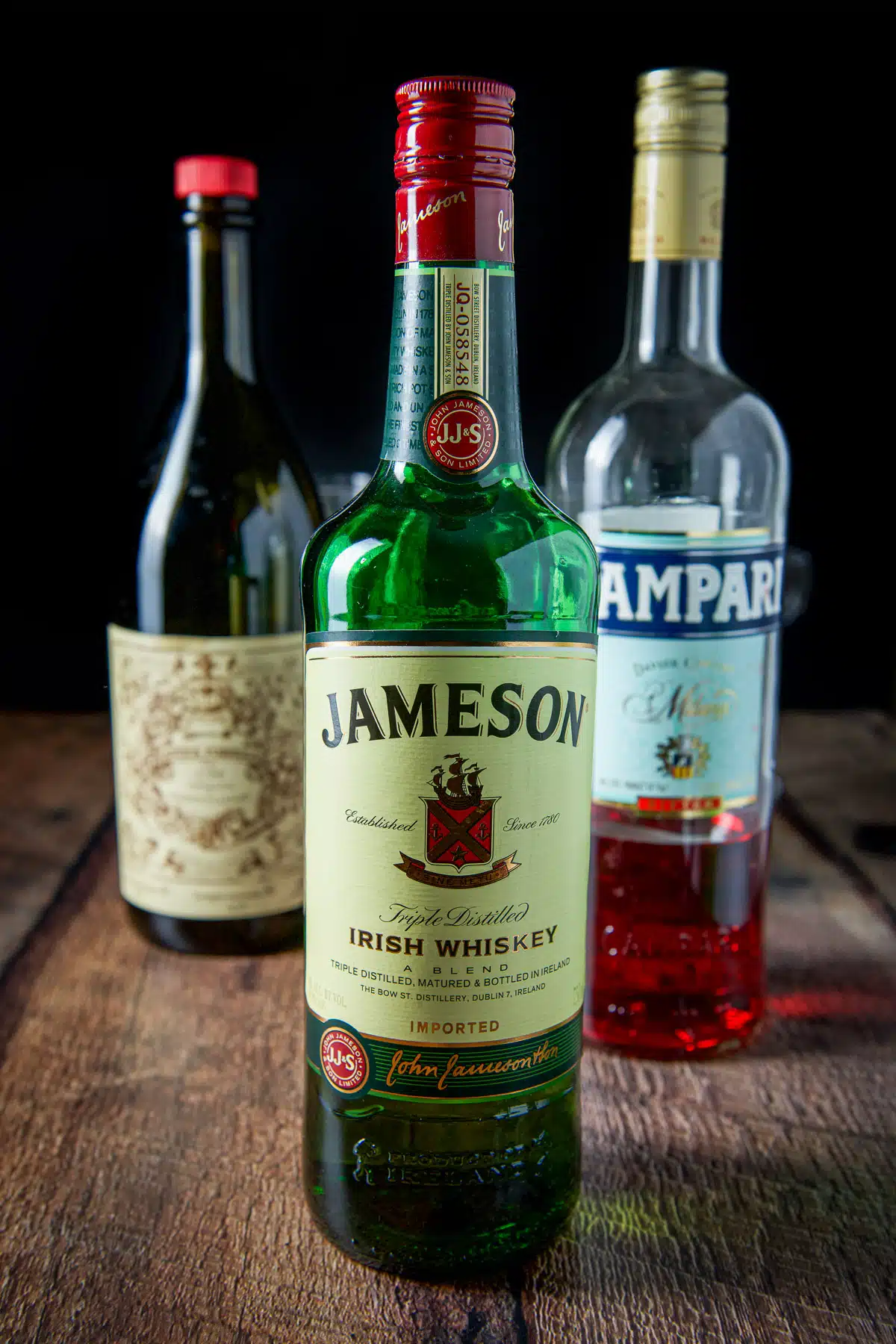 Whiskey, campari, and sweet vermouth on a table