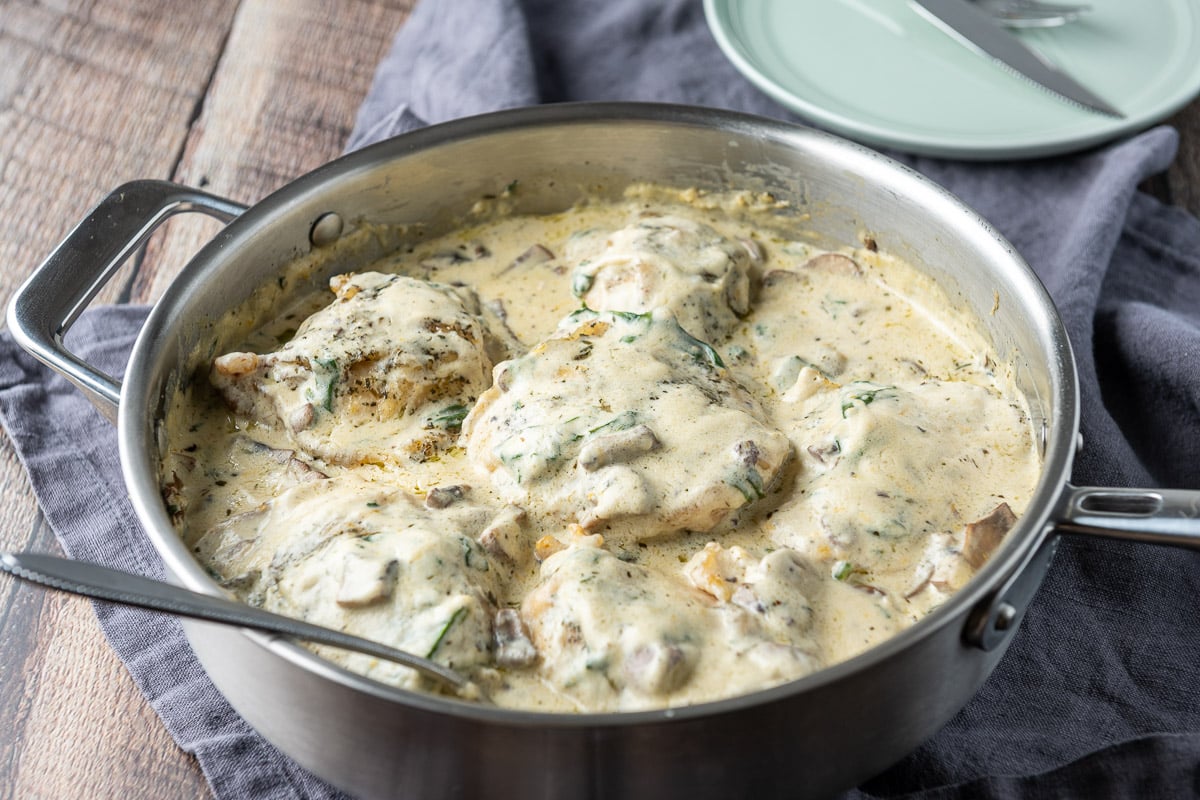Horizontal photo of a metal pan with chicken in a creamy sauce