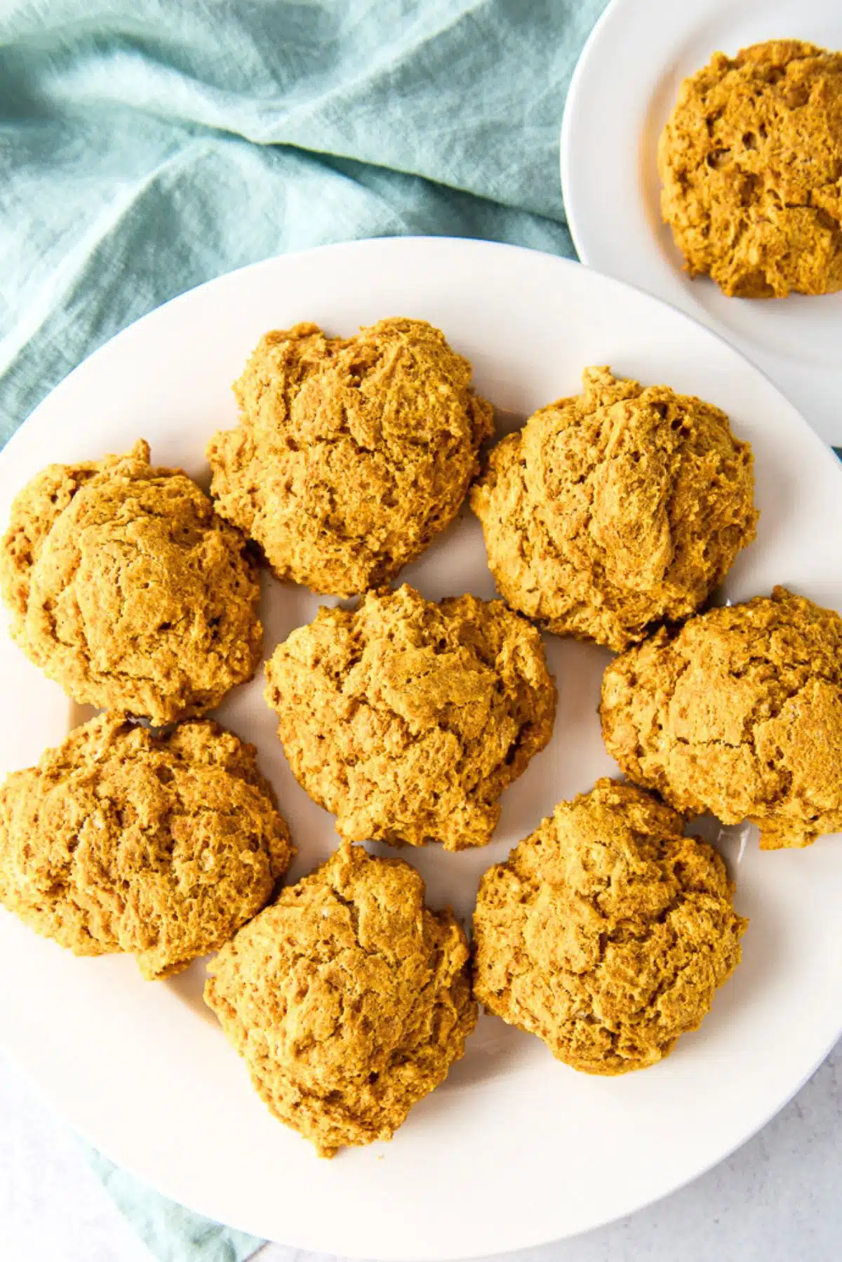 Overhead view of a big plate of potato biscuits with a smaller plate with one
