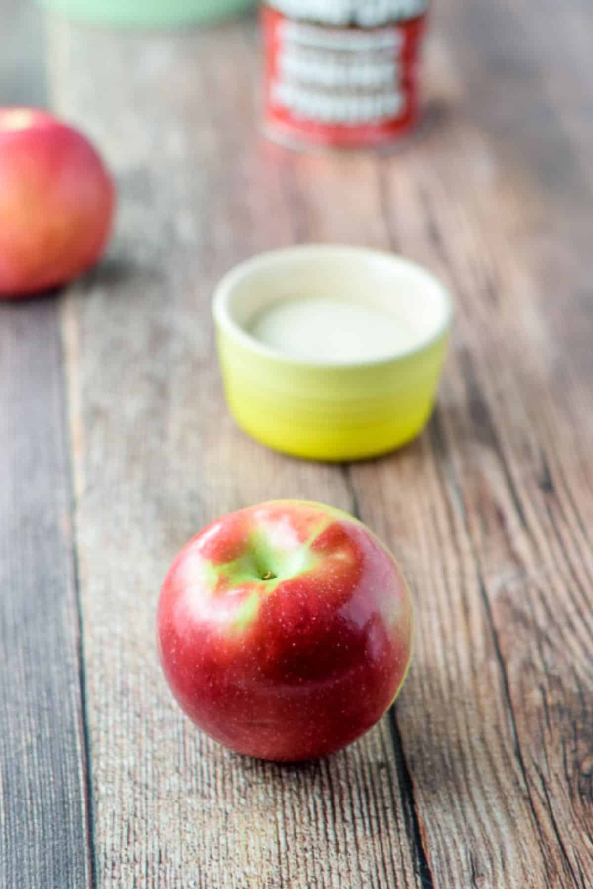 Apples, sugar, baking powder and flour on a wooden table