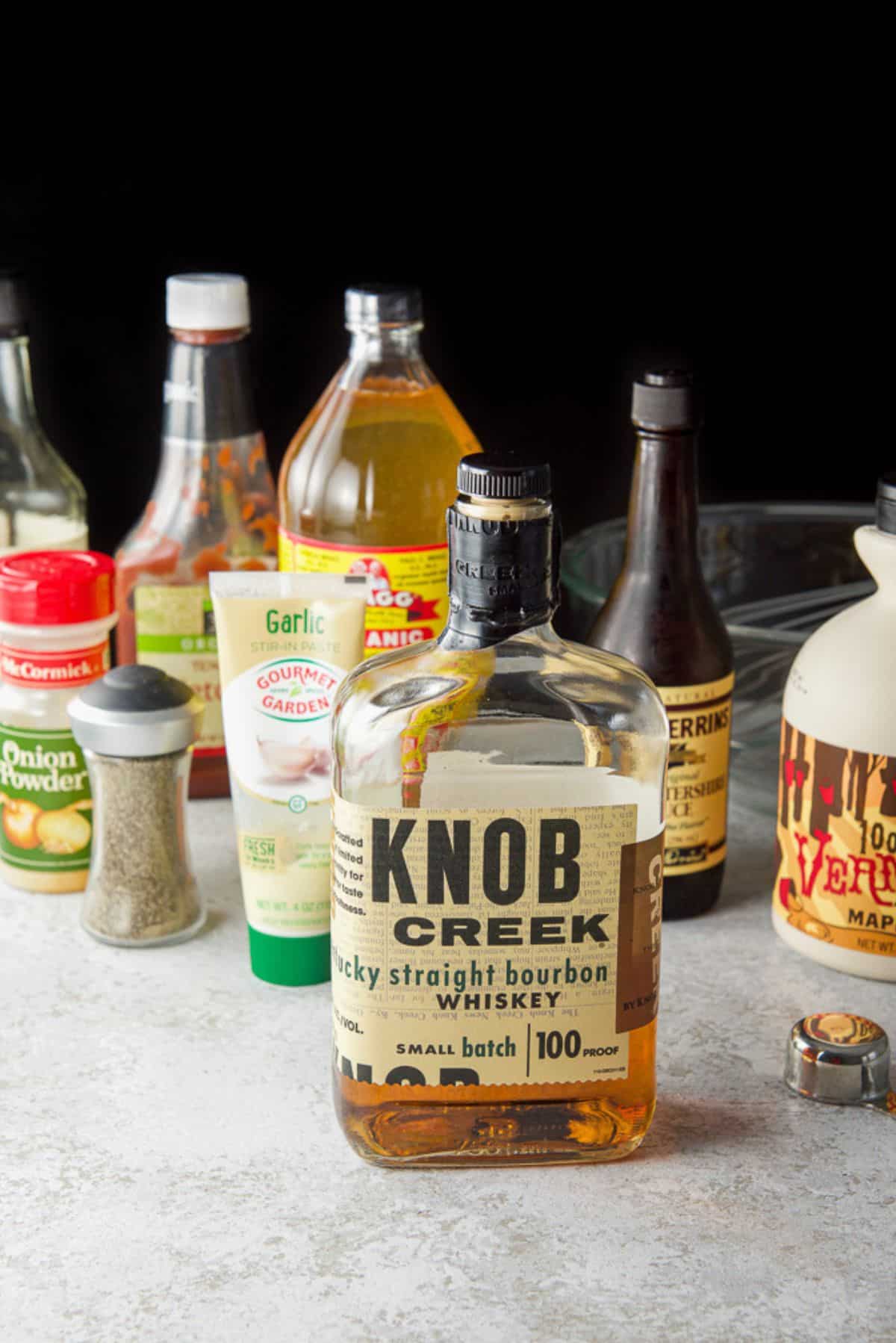 The ingredients for the bourbon sauce - bourbon, maple syrup, Worcestershire sauce, apple cider vinegar, ketchup, soy sauce, garlic and pepper
