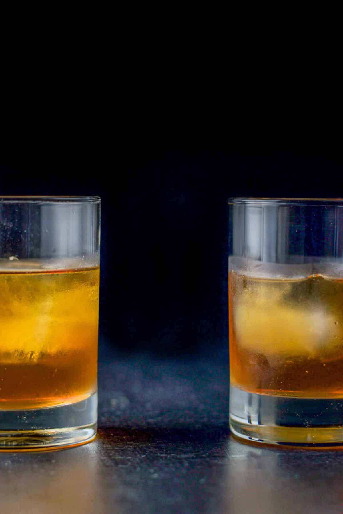 two double old-fashioned glasses filled with the cocktail one on the left and one on the right. You can only see half of each glass