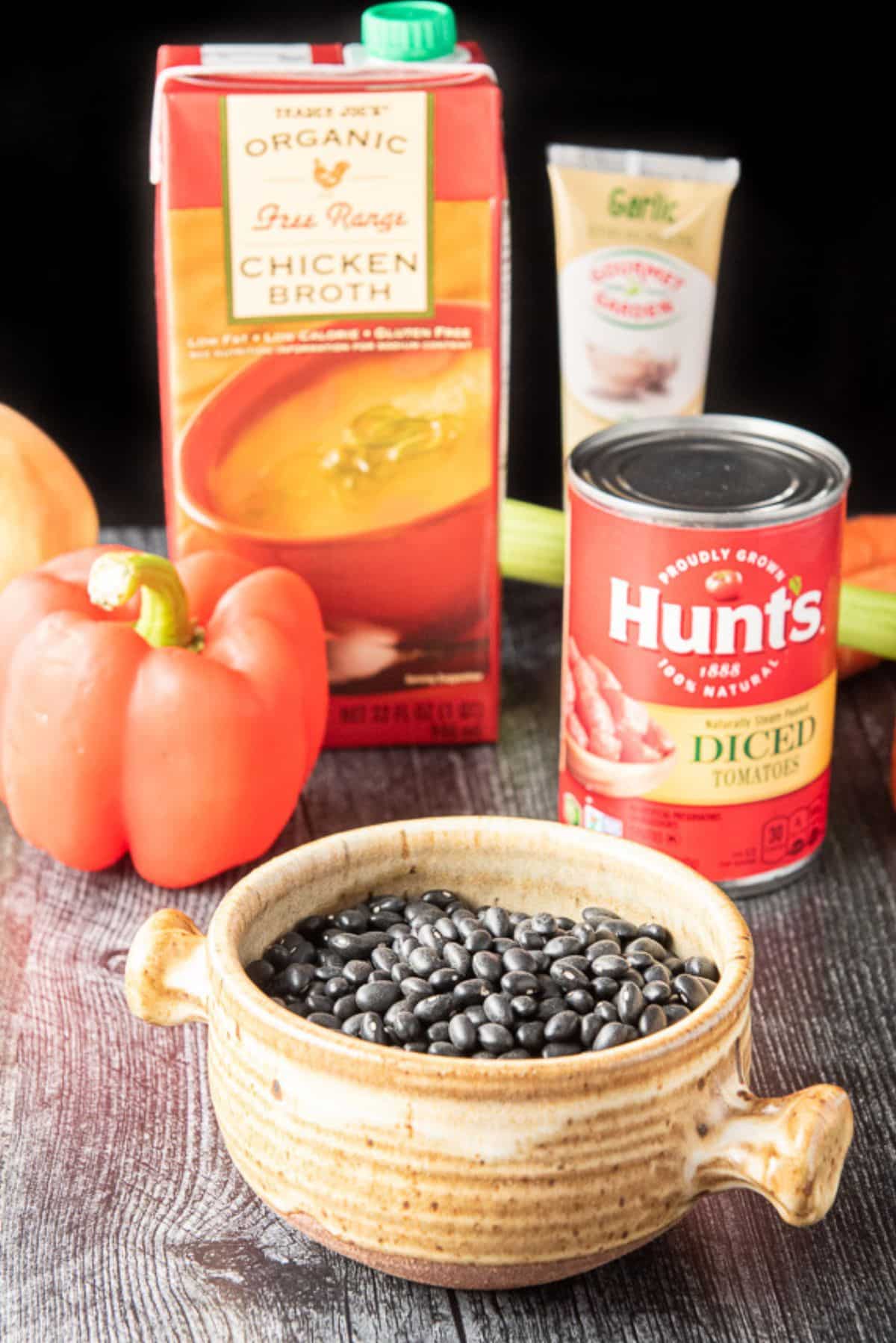 black beans, tomatoes, broth, and vegetables on a table