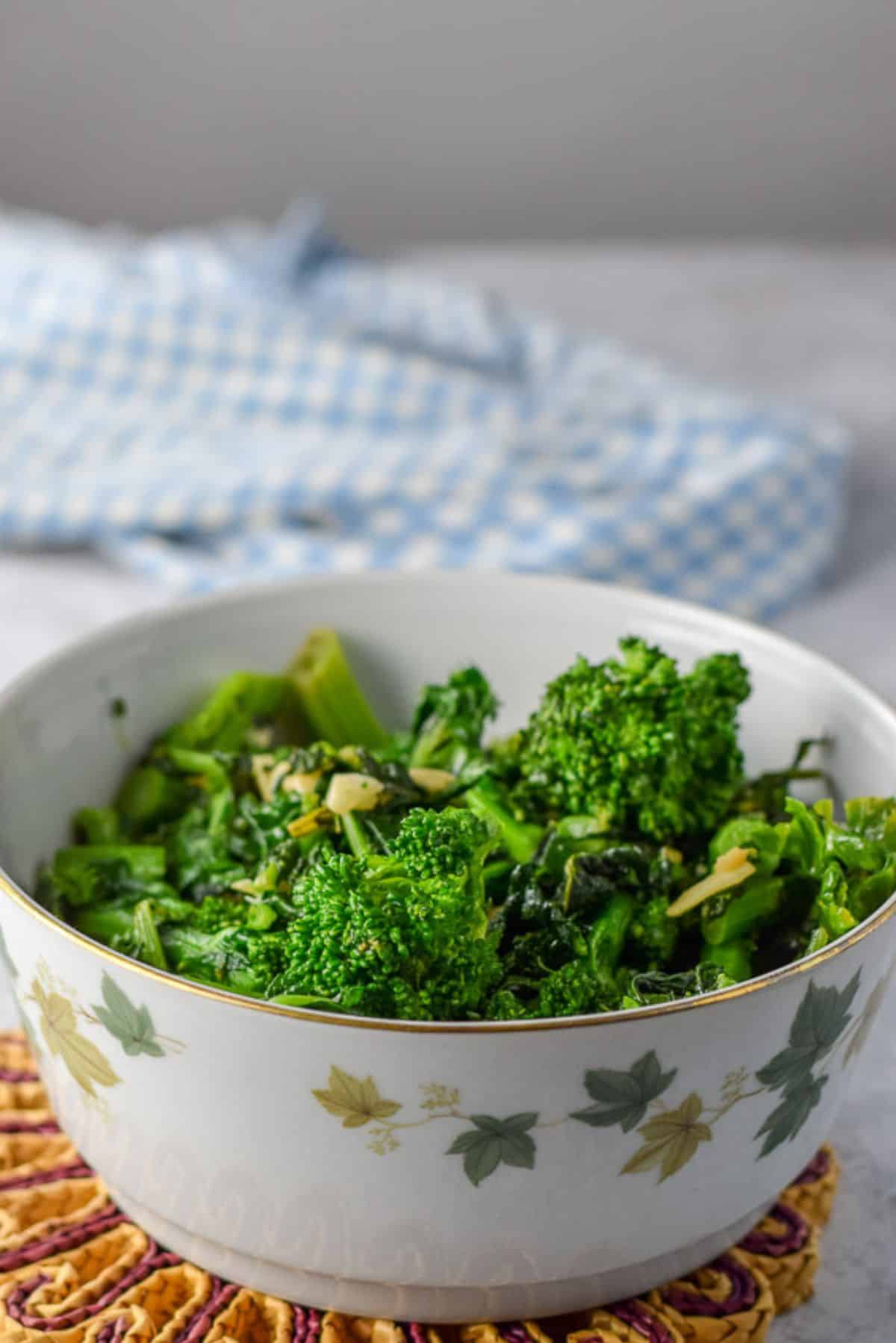 A bowl with leaves on it with the cooked vegetable in it